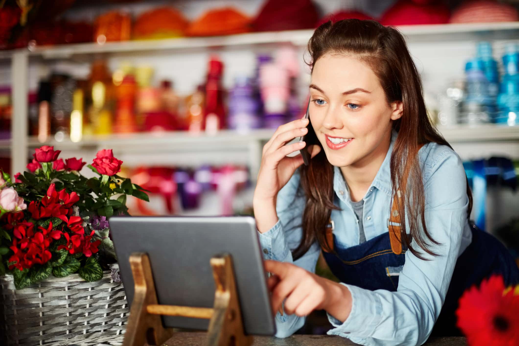 Smiling Florist Using Technologies At Flower Shop